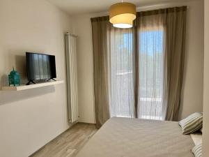 a bedroom with a bed and a window with a television at Donna Nella in Otranto