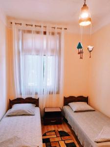 a bedroom with two beds and a window at Casa de Vacanta Rodica in Sulina