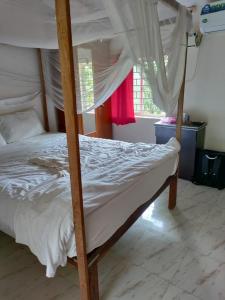 a bedroom with a bunk bed with white sheets at Cabo De Rama Cottage in Cola
