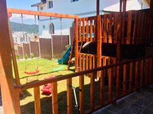 a playground with swings in a yard at Fortuna Cottage Bakuriani in Bakuriani