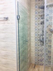 una doccia con porta in vetro in bagno di Fortuna Cottage Bakuriani a Bakuriani