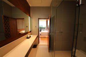 a bathroom with a sink and a mirror and a bedroom at Grand Silver Ray in Ratnapura