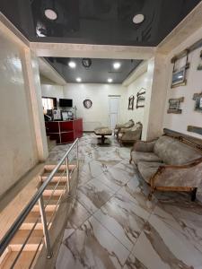 a living room with a marble floor and couches at Hotel Dolphin Batumi in Batumi