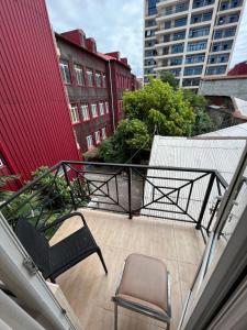 an empty balcony with two chairs and a building at Hotel Dolphin Batumi in Batumi