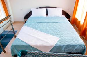 a bed with a blue comforter in a room at Garden's Sunset Αvra in Néa Michanióna