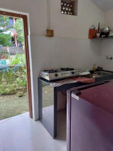 a kitchen with a stove and a counter top at Cabo De Rama Cottage in Cola