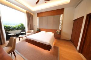 a bedroom with a bed and a large window at Grand Silver Ray in Ratnapura