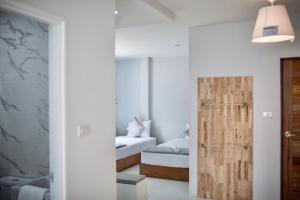 een slaapkamer met een bed en een houten deur bij Thirty Tree Garden House in Chumphon