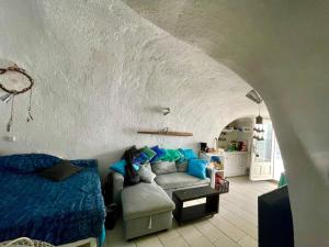 Mermaid Cave Apartment Old Port, Fira في فيرا: غرفة معيشة مع أريكة وسرير