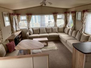 uma sala de estar com um sofá e uma mesa em Deluxe 3 Bedroom Caravan with extra en-suite North Shore em Skegness