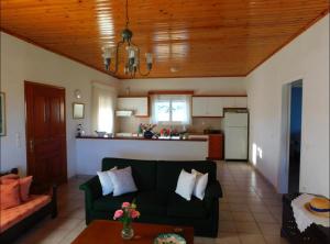 salon z zieloną kanapą i kuchnią w obiekcie Nirvana Guest House w mieście Vasilítsion