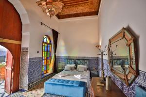 a bedroom with a bed and a mirror at Riad Dar Jeanne in Fès