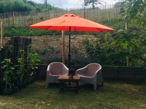 dwa krzesła i stół z parasolem w obiekcie Auberge Sans Souci w mieście Valkenburg