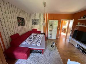 un soggiorno con divano rosso e TV di Zentrumsnahe Ferienwohnung a Dresda