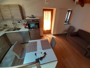 Acero Rosso في Champdepraz: مطبخ وغرفة معيشة مع طاولة وأريكة