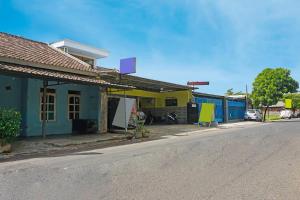 an empty street with a blue and yellow building at OYO 91411 Putih Mulia Homestay Syariah in Lumajang