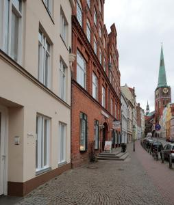 eine Kopfsteinpflasterstraße in einer Stadt mit Gebäuden und einer Kirche in der Unterkunft Apartment Klara in Lübeck