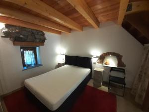Acero Rosso في Champdepraz: غرفة نوم مع سرير أبيض كبير في غرفة