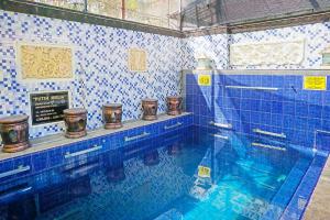 OYO 91411 Putih Mulia Homestay Syariah في Lumajang: حمام سباحة بجدران من البلاط الأزرق