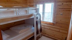 two bunk beds in a wooden room with a window at GÖRNEK TABİAT PARKI in Trabzon