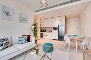 ein Wohnzimmer mit einem weißen Sofa und einem Tisch in der Unterkunft Magnificent apartment in Address Beach Residence, 1 BR, the 6th floor in Dubai