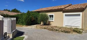 ein Haus mit einem Tor und einer Garage in der Unterkunft Gites de la Casasole in Vogüé