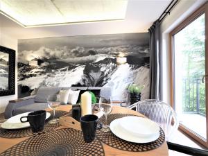 a dining room table with a mountain mural on the wall at VIP APARTAMENTY Chałubińskiego APART in Zakopane