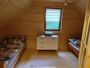 a bedroom with two beds in a log cabin at Domek na Mazurach w otulinie leśnej "Leśne zacisze" in Wydminy