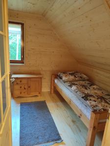 1 dormitorio con 1 cama en una cabaña de madera en Domek na Mazurach w otulinie leśnej "Leśne zacisze", en Wydminy