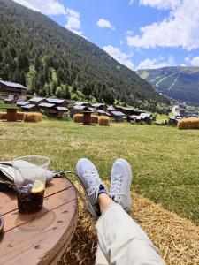 una persona sentada en una mesa de picnic con una bebida en EL RACONET D'INCLES - Peu del Riu 109 - Vall d'Incles - Soldeu, en Incles