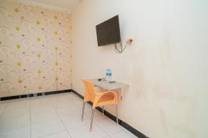 una stanza con un tavolo e una TV su una parete di RedDoorz At Jalan Bukit Keminting a Palangkaraya