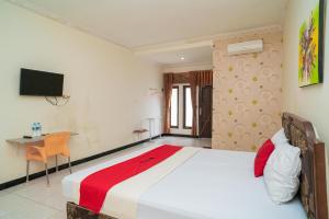 1 dormitorio con 1 cama grande y escritorio en RedDoorz At Jalan Bukit Keminting, en Palangkaraya