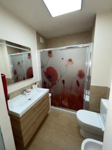 a bathroom with a shower with red flowers painted on it at Apartamento Acogedor y Céntrico - Plaza del Charco in Puerto de la Cruz +1 photo