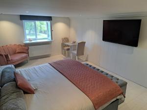 1 dormitorio con 1 cama y TV de pantalla plana en Rêveries, en Roeselare