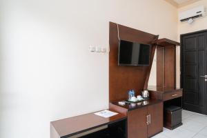 a hotel room with a desk and a tv at RedDoorz @ Wisma Pangrango in Palangkaraya