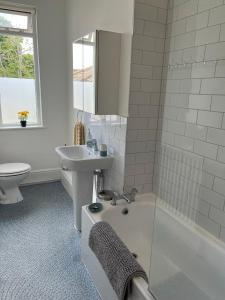 a bathroom with a sink and a tub and a toilet at Tree Tops Apartment in Tunbridge Wells in Royal Tunbridge Wells