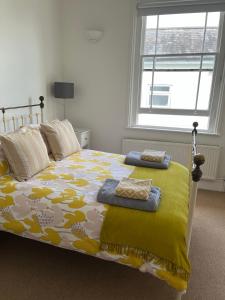 a bedroom with a bed with a yellow and white comforter at Tree Tops Apartment in Tunbridge Wells in Royal Tunbridge Wells