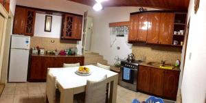 a kitchen with wooden cabinets and a table with a bowl of fruit at Vila Korchari Dardhe in Korçë