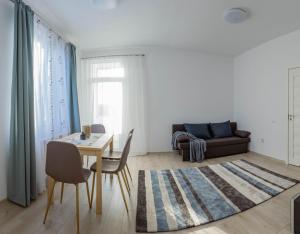 a living room with a table and chairs and a couch at Solomon Apartments Ap 3 in Sîngeorgiu de Mureş +6 photos