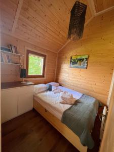 sypialnia z łóżkiem w drewnianym domku w obiekcie Domki Habzówka w mieście Ostre