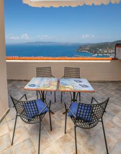 2 mesas y 2 sillas en un balcón con vistas al océano en Residence Sole Dell'Argentario, en Porto Santo Stefano