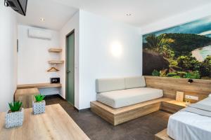 een slaapkamer met een bed en een bank in een kamer bij Epicentrum Suites Fresh in Limenaria