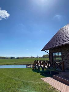 a pavilion with a table and a bench next to a lake at Bareišių sodyba in Moškėnai