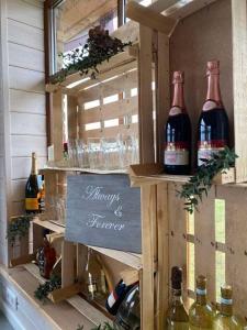 a display of wine bottles and glasses on a shelf at Bareišių sodyba in Moškėnai