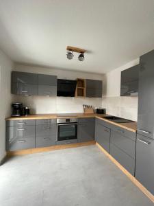 a large kitchen with gray cabinets and appliances at BNB Klinga in Klinga