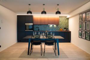 una cucina con tavolo e sedie blu di Green Appart - A&B Best Quality - Mons City Center a Mons