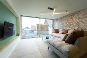un soggiorno con due divani e una grande finestra di Green Appart - A&B Best Quality - Mons City Center a Mons