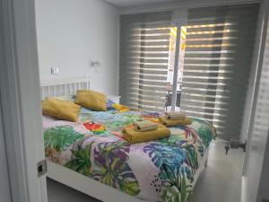 Un dormitorio con una cama con almohadas amarillas. en Monsenor en Playa del Cura
