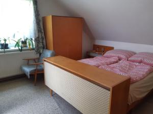 a bedroom with a bed and a desk and a window at Apartmán v rodinném domě in Dětenice