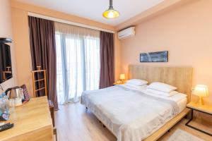 a bedroom with a bed and a large window at Hotel N16 in Batumi